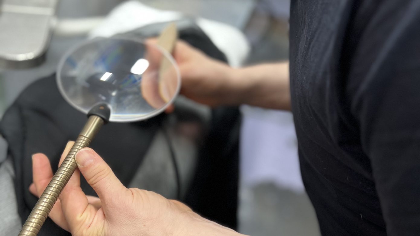 Inspecting an item of clothing with a magnifying glass
