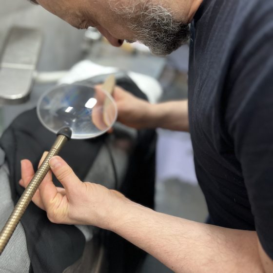 Inspecting an item of clothing with a magnifying glass