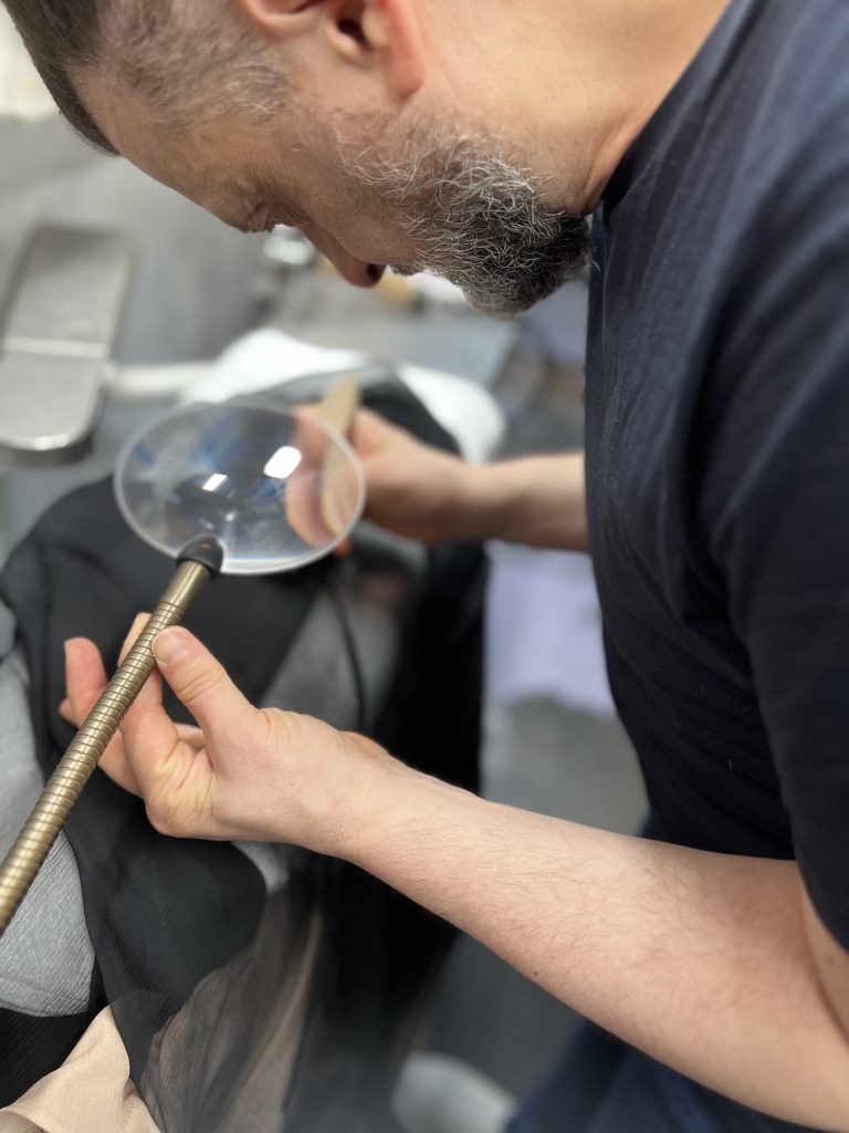 Inspecting an item of clothing with a magnifying glass